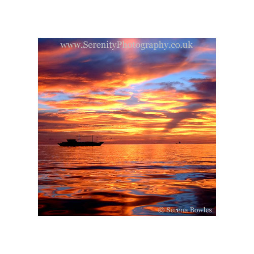 Dazzling orange sunset viewed from the water. Boracay, the Philippines .